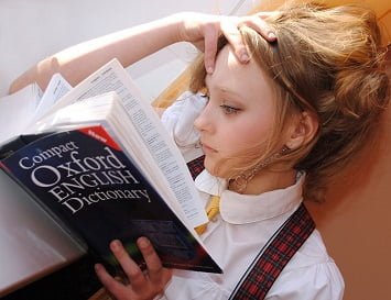 Girl reading dictionary. Anglais pour le travail